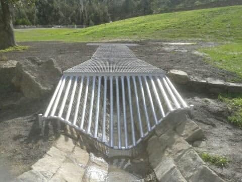 Metal drain grate across stream