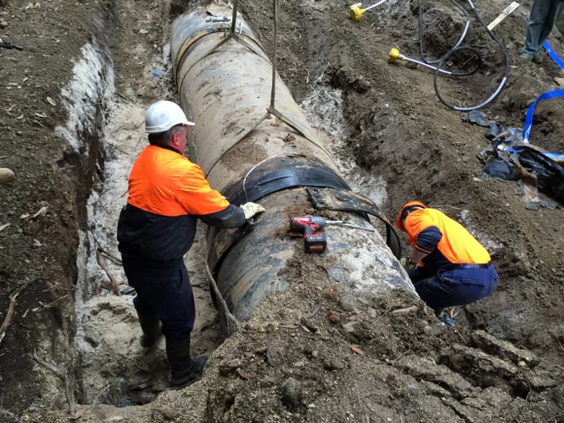 Workers repairing large pipeline