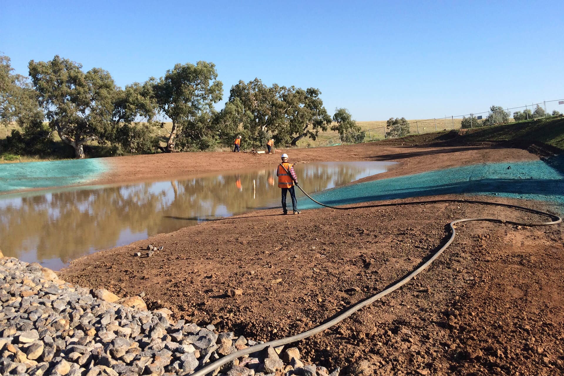 Worker irrigating water pond