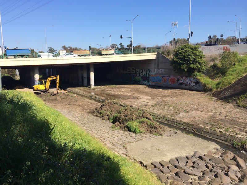 Excavator under bridge clearing