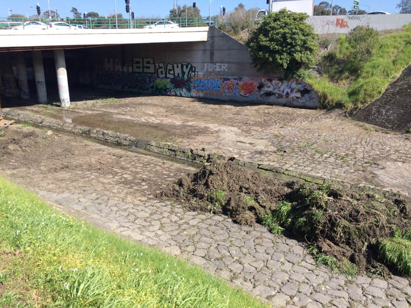 Dry riverbed under bridge