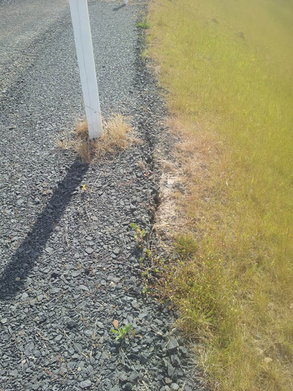 Gravel and grass next to pole