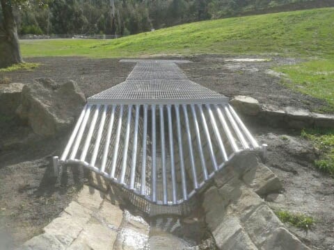 Metal drain grate across stream