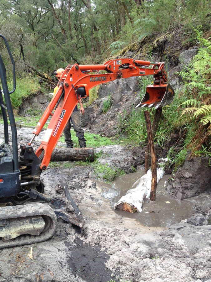 Excavator moving log outdoors