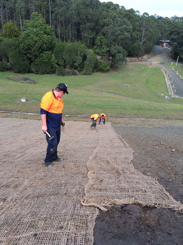 Workers laying erosion control mat