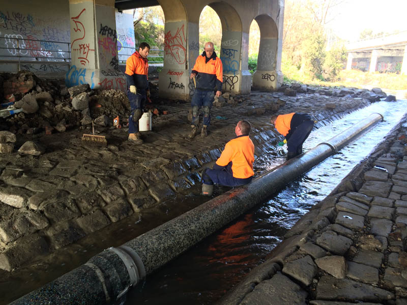 Workers repair large pipe