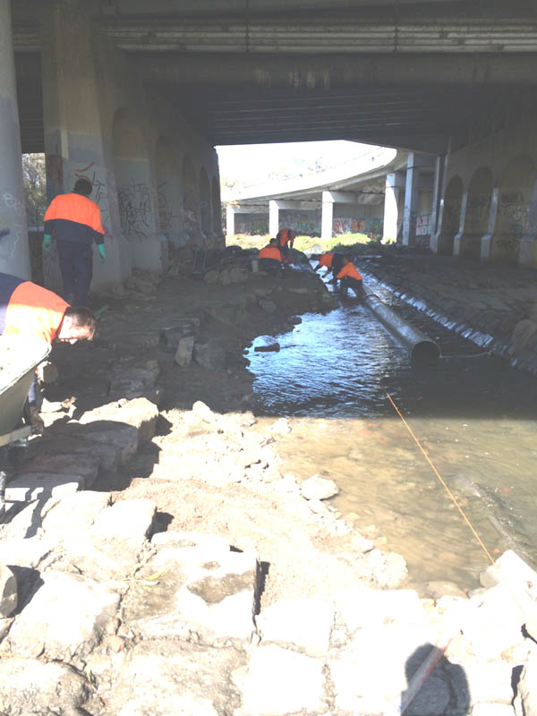 Workers under a bridge
