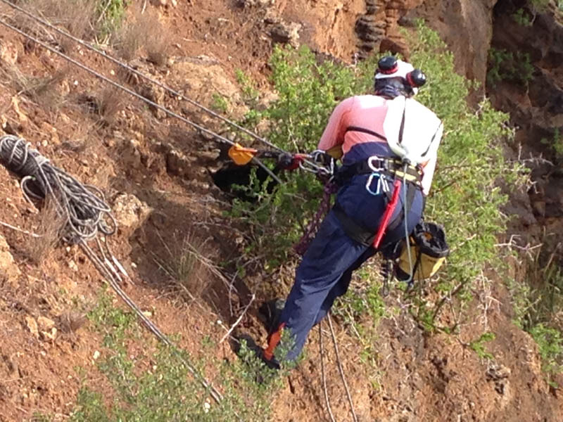 Rescuer rappelling down cliff