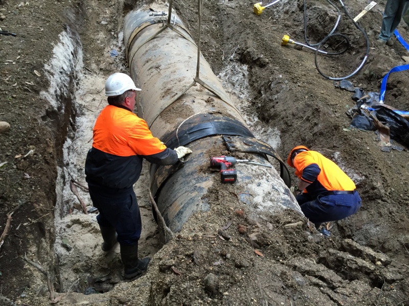 Workers repairing large pipeline
