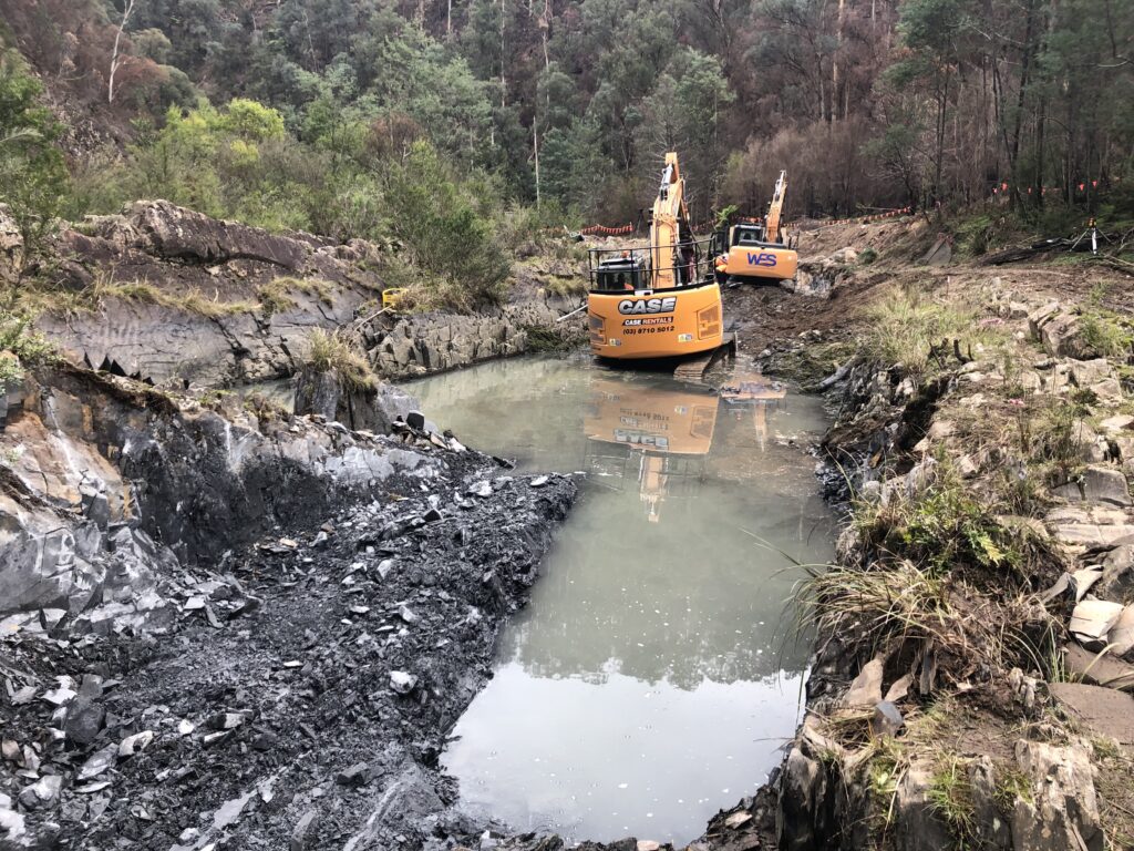 Excavators in muddy river
