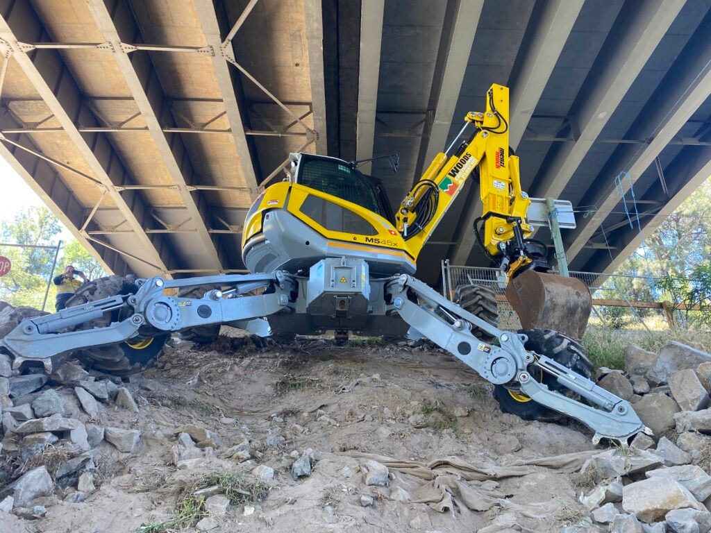 Yellow excavator under bridge