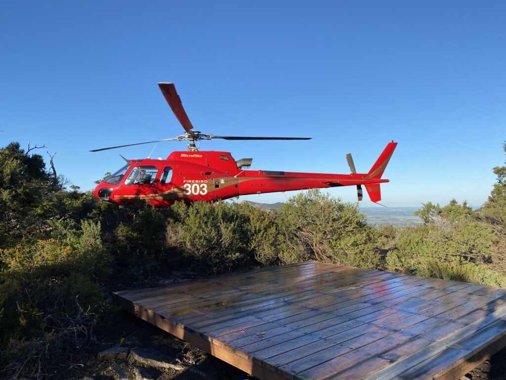 Red helicopter lands near water