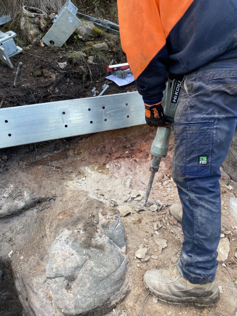 Worker breaking ground with jackhammer